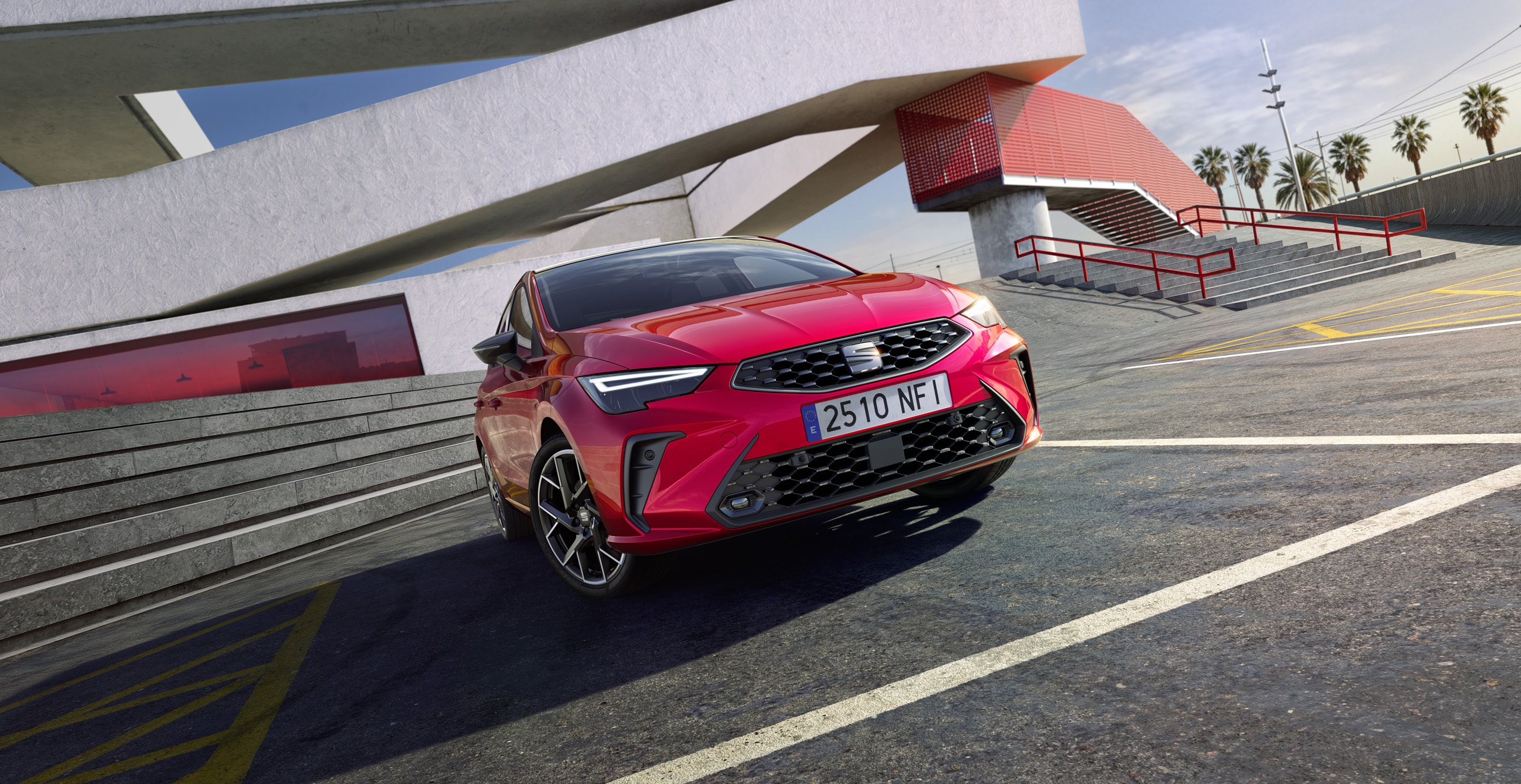 New SEAT Ibiza hatchback in vibrant red parked under modern architecture, showcasing bold front grille, sharp LED headlights, and sporty alloy wheels.