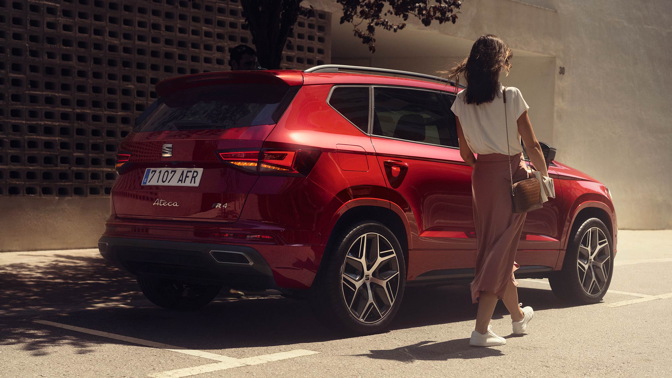 woman-walking-next-to-seat-ateca-velvet-red-colour