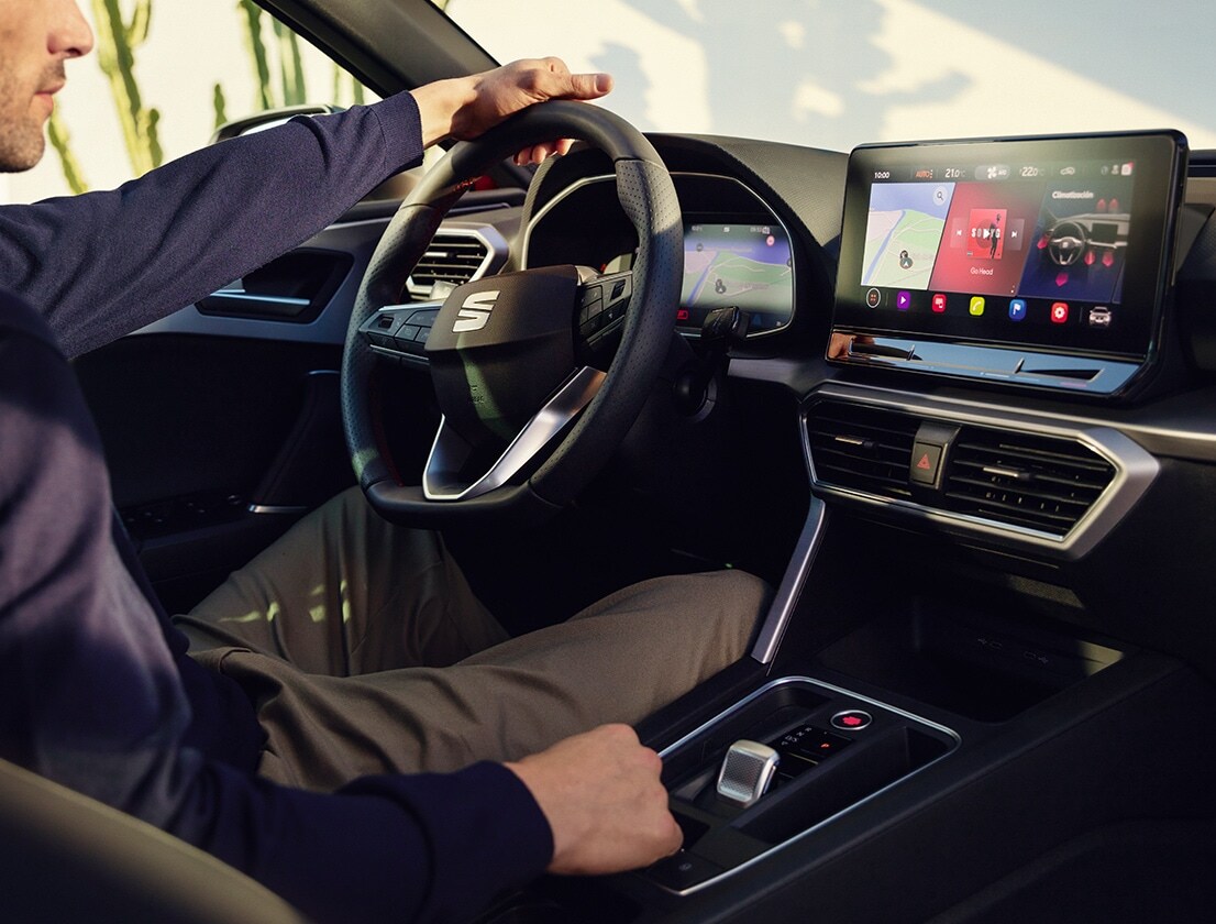 interior view of a man driving a seat leon using the dashboard