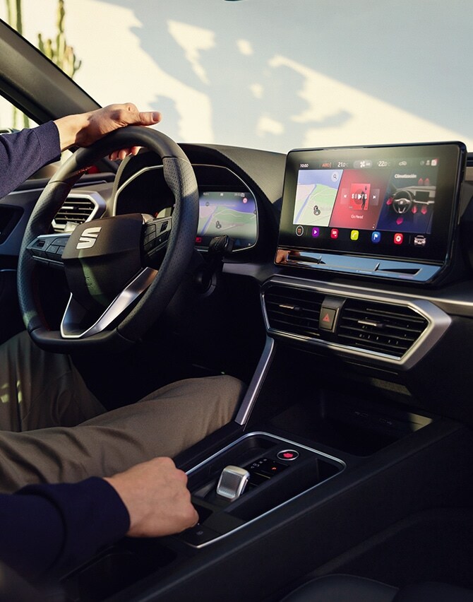 interior view of a man driving a seat leon using the dashboard