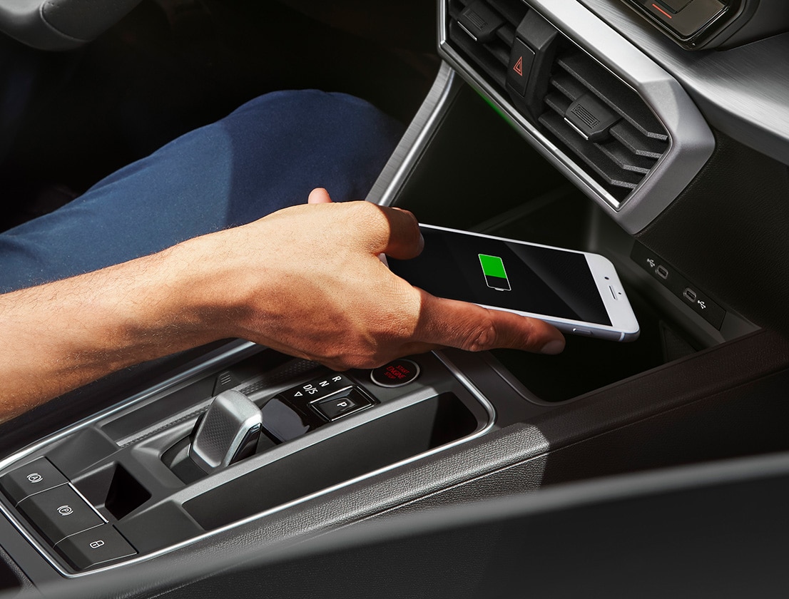 man charging his smartphone with the seat leon wireless charger