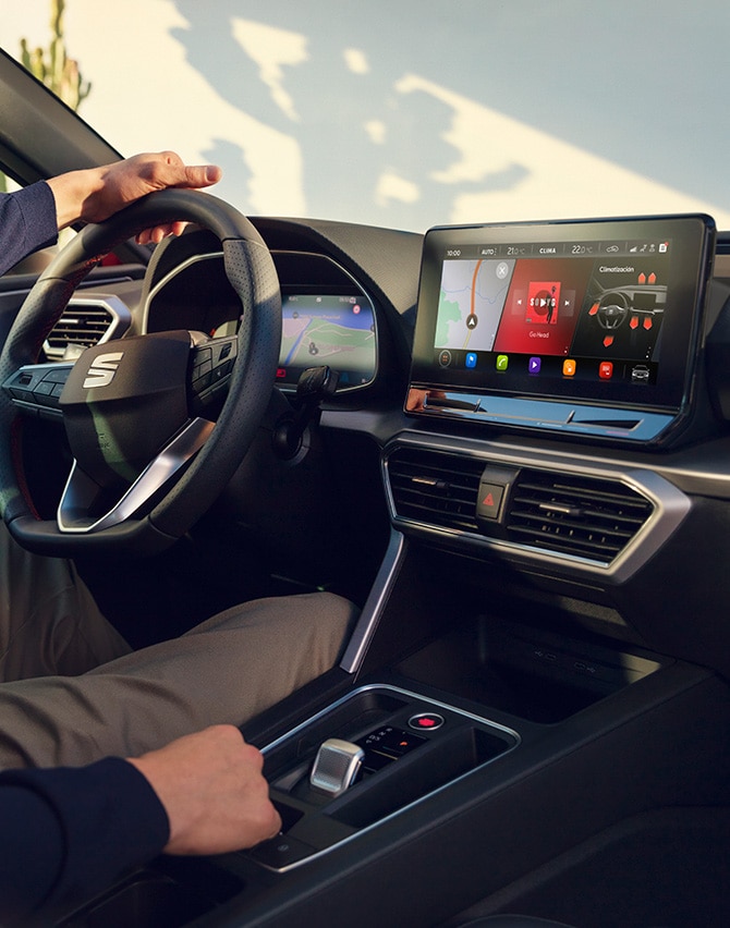 interior view of a man driving a seat leon using the dashboard